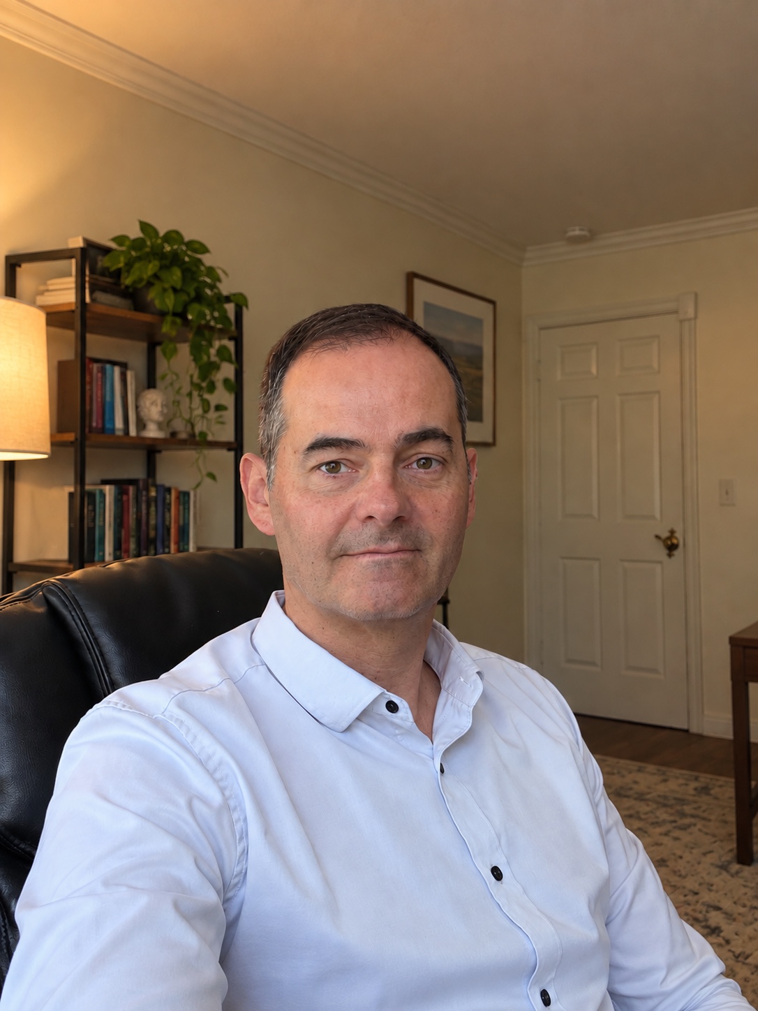 Roberto Figueroa, MD, PhD, seated in his office without glasses